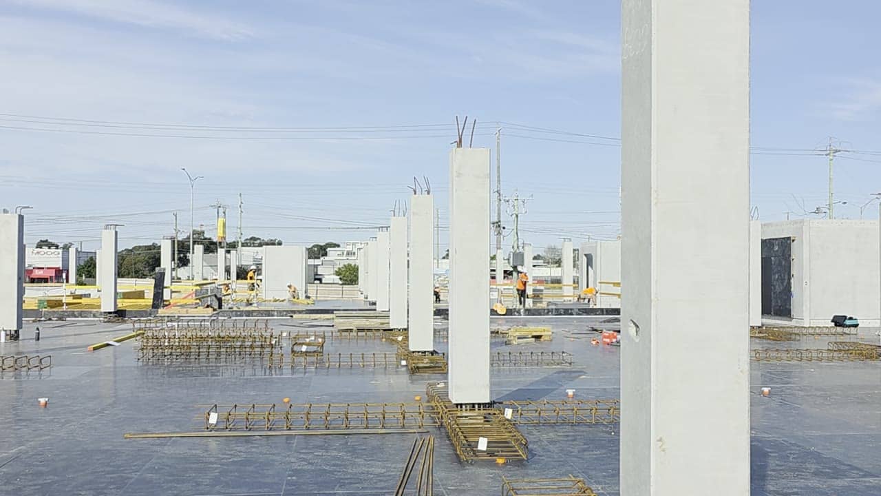 Precast columns and reinforcement cages laid out across a deck on a Spartan site